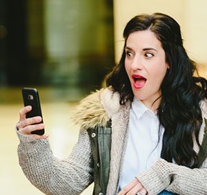 Surprised woman looking at mobile phone